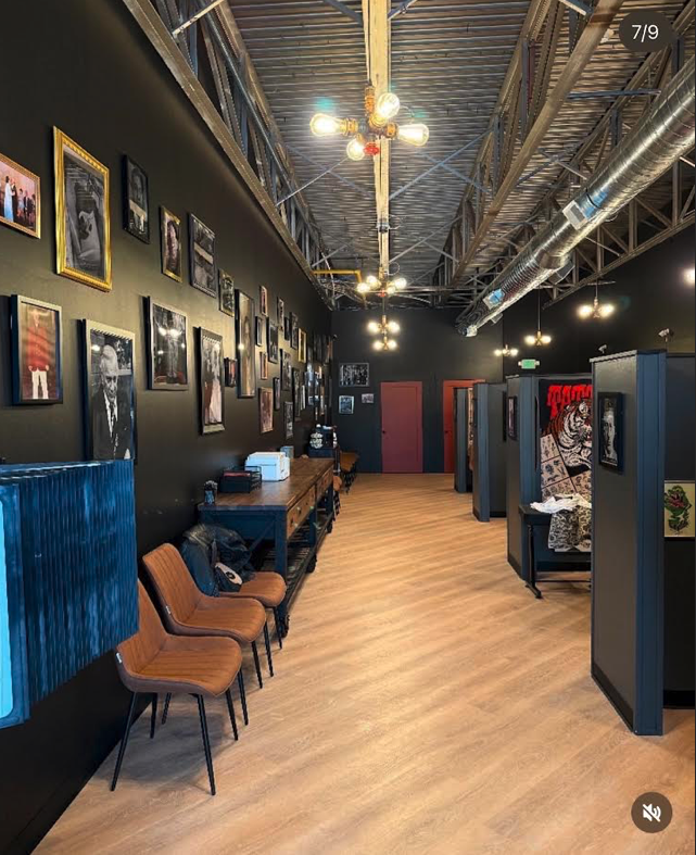 Studio interior with framed artwork and individual tattoo stations