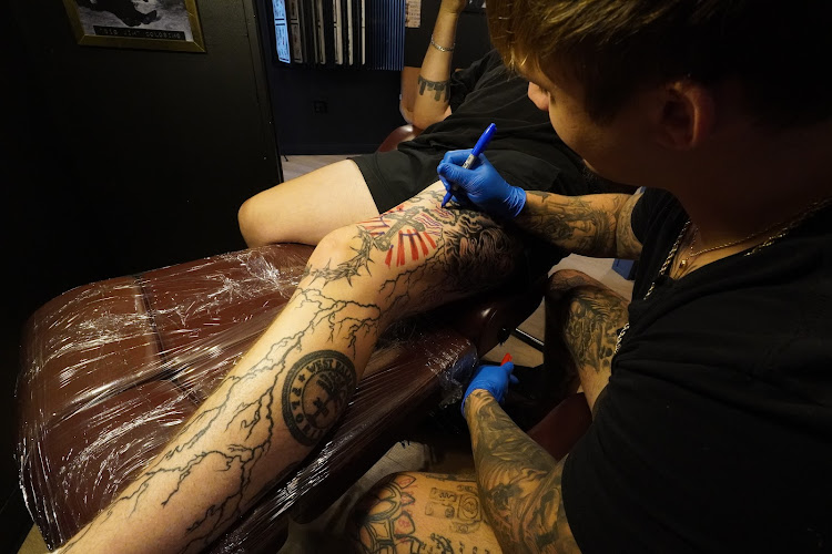 Tattoo artist at work inside Bound by Blood Tattoo Studio
